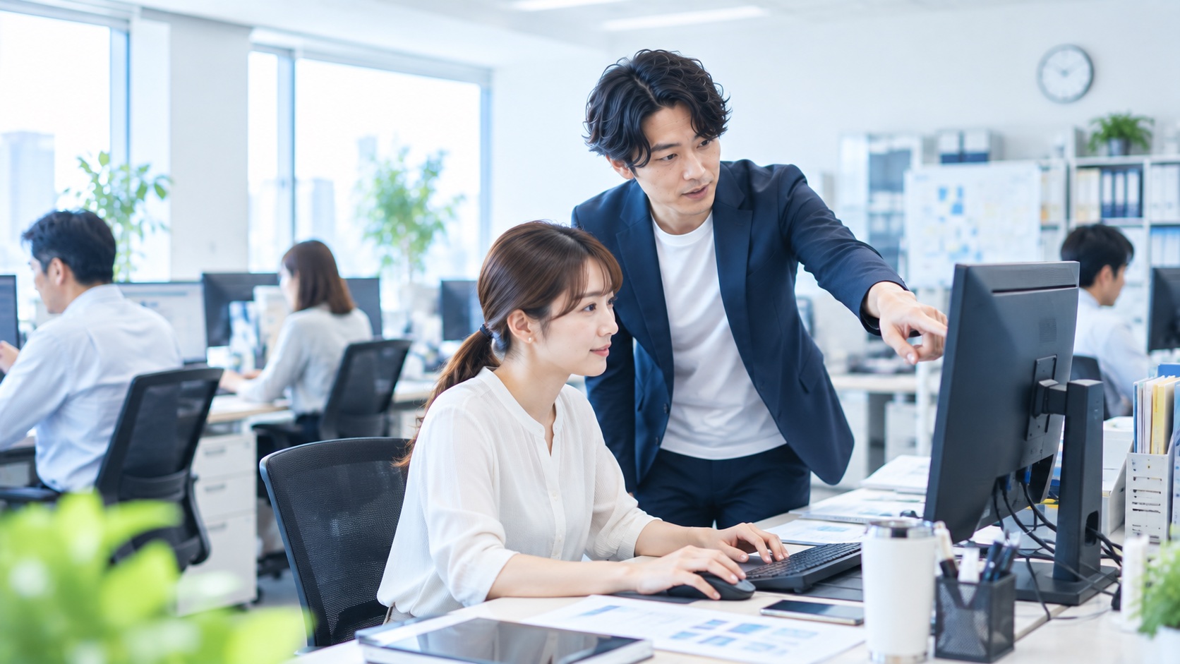 パソコンの画面を見ながら導入を支援する様子